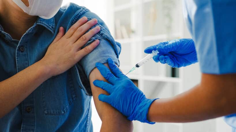 young asian lady nurse giving covid flu antivirus vaccine shot senior male patient