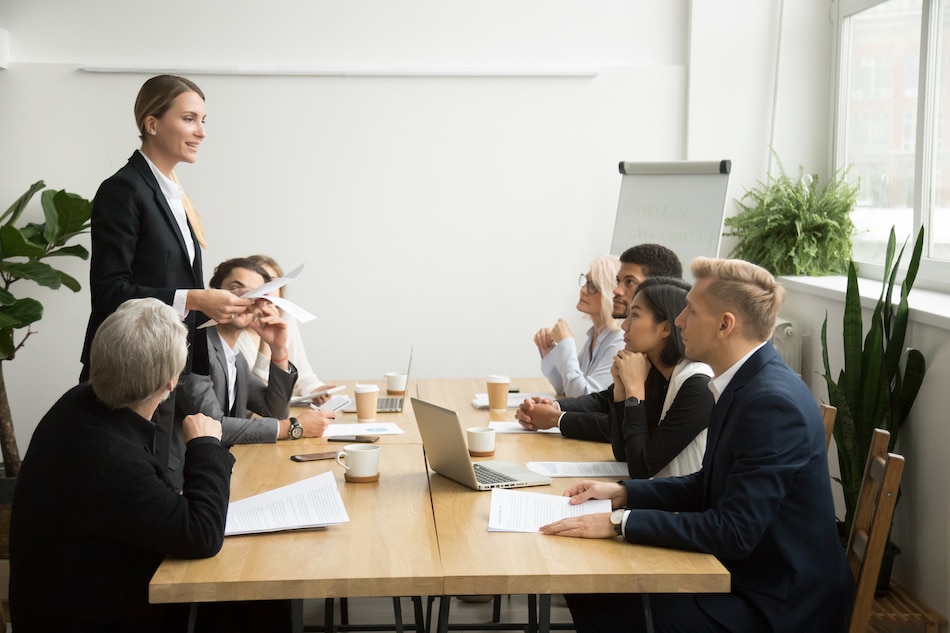 successful female boss leading team meeting talking multiracial employees